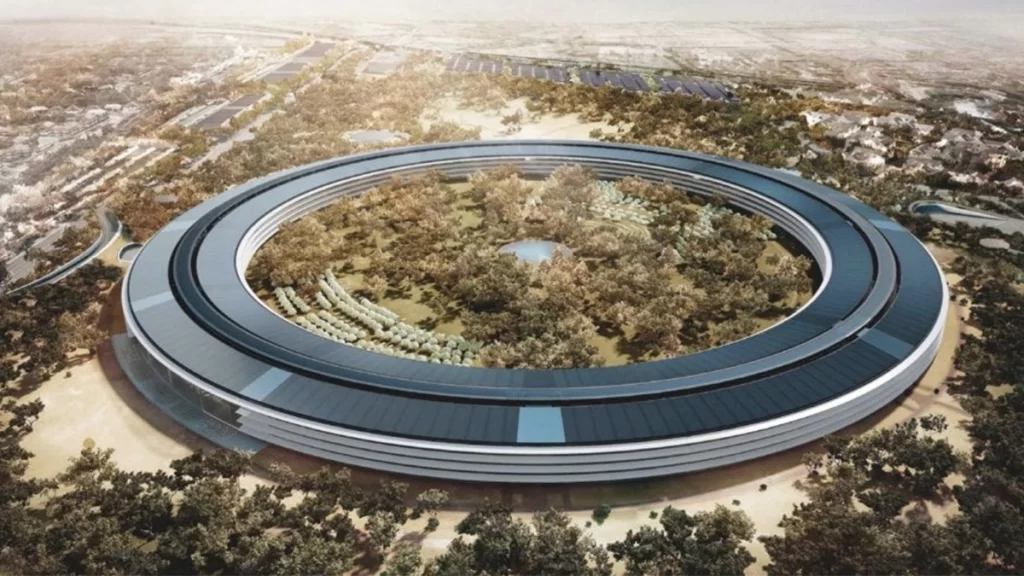 A drone image of Apple Park, the headquarters of technology company, Apple. It is one large circle, with trees and a lake in the middle of the circle.