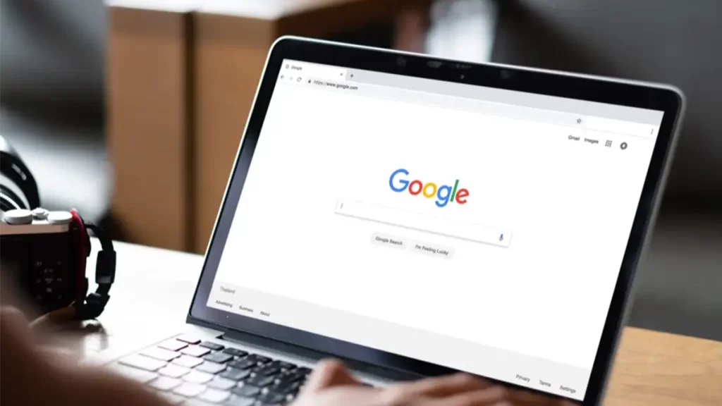 A windows laptop displaying the home page of the Google search engine.