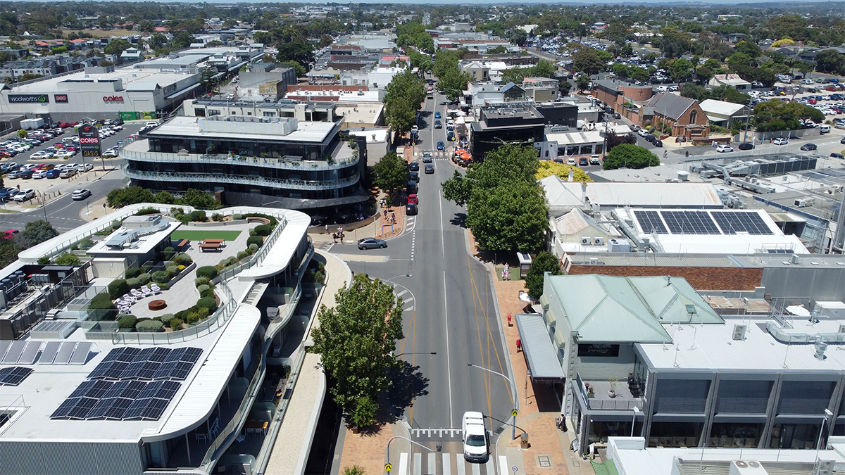 A drone image of the main street in Mornington highlighting a handful of cars driving down the street in the middle of a sunny day.