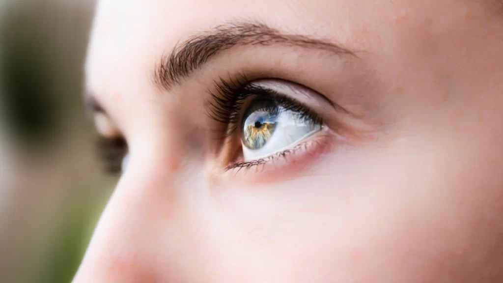 A caucasian female looking to the left of image, with her left high wide open.