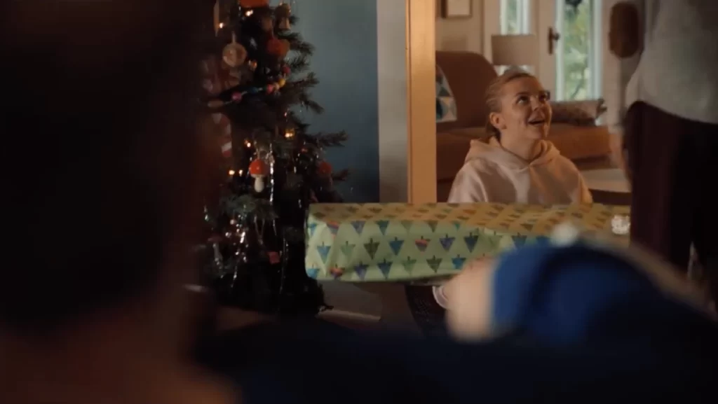 A teenage girl opens up a Christmas gift from her parents.